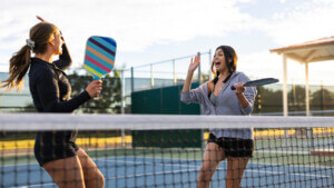 two women playing pickleball