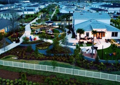 aerial view of EverBe neighborhood at twilight - cafe lights are strung above a green space between two structures where EverBe creates community